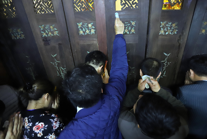 Dòng người xô nhau xoa tiền cầu may sau khai ấn đền Trần